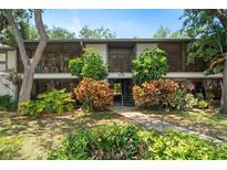 Inviting condo building with lush landscaping, mature trees and screened in balconies at 3241 Fox Chase N Cir # 106, Palm Harbor, FL 34683
