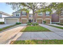Charming townhome featuring a well-manicured lawn, private garages, and inviting curb appeal at 4916 Chatham Gate Dr, Riverview, FL 33578
