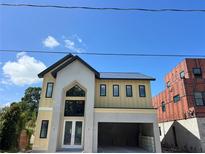 New construction with modern design, gray accents, large windows, and an attached two-car garage at 812 W Braddock St, Tampa, FL 33603