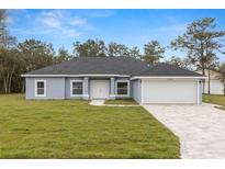 Charming single-story home with a paved driveway, attached garage, and well-manicured lawn at 10262 Maybird Ave, Weeki Wachee, FL 34613