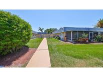 Community courtyard featuring meticulously maintained green spaces, lush landscaping and well-lit walkways at 1802 Bedford Ter # 187, Sun City Center, FL 33573