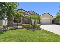 Charming single-story home with stone accents, manicured lawn, and mature landscaping at 18796 Obregan Dr, Spring Hill, FL 34610