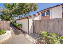 Charming walkway leading to a well-maintained home with mature landscaping and wooden fence at 1881 N Hercules Ave # 1303, Clearwater, FL 33765