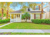 Charming two-story home with a welcoming front porch, lush lawn and mature landscaping at 20121 Bending Creek Pl, Tampa, FL 33647