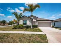 Charming single-story home featuring a well-manicured lawn and a two car garage at 7202 Ozello Trail Ave, Ruskin, FL 33573