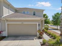 Beige two-story home with two-car garage, well-manicured lawn, and concrete walkway at 10742 Verawood Dr, Riverview, FL 33579