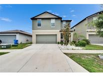 Two-story home with a two-car garage and a well-manicured lawn and landscaped garden at 15718 Fort Island Pl, Sun City Center, FL 33573