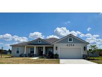 Charming one-story home with blue and gray exterior paint and well-manicured lawn at 4294 Cork Rd, Plant City, FL 33565