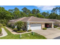 Charming single-story home with a two-car garage, manicured landscaping, and a welcoming entrance at 4425 Connery Ct, Palm Harbor, FL 34685