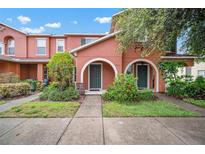 Charming townhome with lovely landscaping, sidewalk and covered entrances with beautiful arches and green doors at 6831 Dartmouth Hill St, Riverview, FL 33578