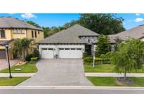 Beautiful one-story home with three-car garage, paver driveway, stone accents, and well-maintained landscaping at 922 Grand Cresta Ave, Brandon, FL 33511