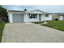 Charming single-story home featuring a brick driveway and attached one car garage at 10817 Fillmore Ave, Port Richey, FL 34668