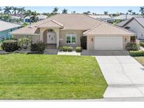 Charming single-story home featuring a tile roof, well-manicured lawn, and an attached two-car garage at 1137 Treasure Cay Ct, Punta Gorda, FL 33950
