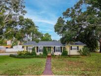 Charming single story home with mature trees, neat landscaping, walkway, and neutral color scheme at 1180 39Th N St, St Petersburg, FL 33713