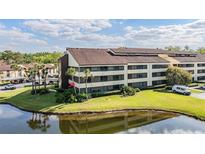 Condo complex showcasing lush landscaping, water view, and ample parking at 13610 S Village Dr # 4212, Tampa, FL 33618