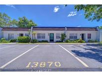 Charming condo with a parking spot right in front, surrounded by lush landscaping and blue skies at 13870 Oakwood Ln # 13870, Seminole, FL 33776