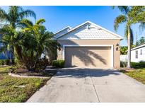 Charming single-story home with a two-car garage and tropical landscaping at 1430 Blue Horizon Cir, Bradenton, FL 34208
