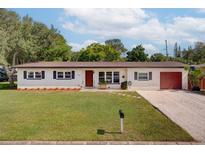 Charming single-story home featuring a well-maintained lawn, neutral paint, and a neatly manicured landscape at 1644 Scott St, Clearwater, FL 33755