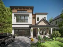 Striking modern home with a glass garage door, covered porch, and meticulous landscaping at 3406 W Arch St, Tampa, FL 33607