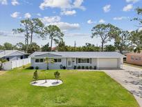 Charming single-story home with a manicured front lawn and a spacious driveway leading to an attached garage at 4501 Huntington Ne St, St Petersburg, FL 33703