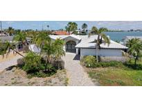 An aerial view showing the front facade, lush palm trees, and waterway location at 511 64Th Ave, St Pete Beach, FL 33706