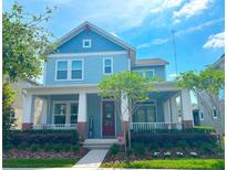 Charming blue two-story home with a welcoming front porch, landscaped yard, and well-maintained exterior at 6011 Caldera Ridge Dr, Lithia, FL 33547