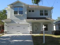 Charming two-story home featuring an attached two-car garage and a well-maintained lawn at 603 5Th S St, Safety Harbor, FL 34695