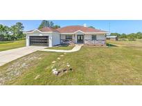 Charming single-story home featuring a well-manicured lawn and an attached two-car garage at 7509 Hackamore Rd, Zephyrhills, FL 33541