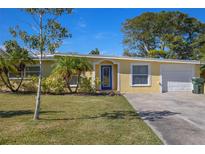Charming single-story home with a well-manicured lawn and blue front door entrance at 12384 144Th St, Largo, FL 33774