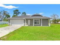 Charming single-story home featuring a well-manicured lawn and attached two-car garage at 13193 Paxton Ave, Weeki Wachee, FL 34614