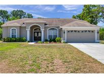 Charming single-story home featuring a two-car garage and manicured lawn at 13290 Don Loop, Spring Hill, FL 34609