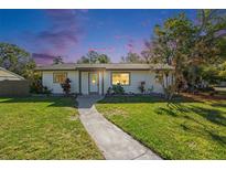 Charming single-story home featuring a well-maintained lawn and inviting walkway under a beautiful dusk sky at 1601 Paloma Ln, Dunedin, FL 34698