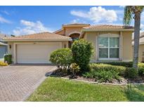 Charming single-story home featuring a tile roof, brick driveway, and well-maintained landscaping at 16055 Golden Lakes Dr, Wimauma, FL 33598