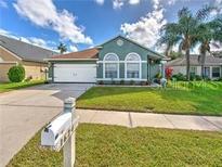 Charming single-story home with well-manicured lawn, driveway, and attached garage at 1624 Maximilian Dr, Wesley Chapel, FL 33543