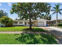 Charming single-story home with a well-manicured lawn and mature landscaping, including a large shade tree at 1751 Ashton Abbey Rd, Clearwater, FL 33755
