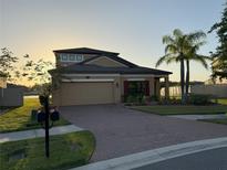 Charming one-story home features a well-manicured lawn, brick driveway and a two-car garage at 19514 Sea Myrtle Way, Tampa, FL 33647
