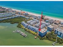 Stunning aerial view of waterfront condo with beach access and boat dock, offering luxury coastal living at 19925 Gulf Blvd # 503, Indian Shores, FL 33785