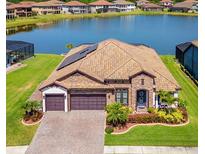 Beautiful lakefront home with a tile roof, manicured lawn, and a three-car garage at 28857 Picana Ln, Wesley Chapel, FL 33543