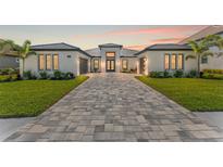 Elegant single-story home boasts a well-maintained lawn, and a spacious brick driveway at 33228 Kateland Dr, Wesley Chapel, FL 33545