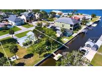 An aerial view of waterfront property featuring lush landscaping, a dock, and water access perfect for boaters at 5425 Bluepoint Dr, Port Richey, FL 34668