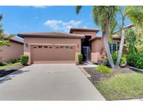 Charming single-story home featuring a tile roof, two-car garage, and lush landscaping at 5728 Sunset Falls Dr, Apollo Beach, FL 33572