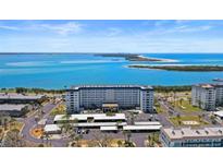 Stunning aerial view of a waterfront condo with beautiful blue water and sandy beach in the background at 7 Elgin Pl # 510, Dunedin, FL 34698