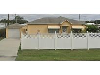 Charming single-story home with a white fence and a detached garage, offering curb appeal and privacy at 7435 46Th N Ave, St Petersburg, FL 33709
