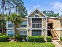 Charming two-story condo featuring a palm tree, verdant lawn, and classic architectural details under a clear blue sky at 9481 Highland Oak Dr Dr # 508, Tampa, FL 33647