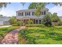 Charming two-story home with manicured lawn and inviting brick pathway at 1211 S Druid Ln, Tampa, FL 33629