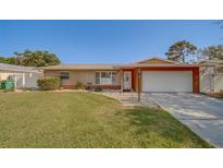 Charming single-story home with a well-maintained lawn, neutral exterior, and attached two-car garage at 13057 89Th Ave, Seminole, FL 33776