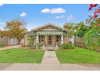 Charming bungalow with a green striped awning, landscaped yard, and inviting curb appeal at 2450 3Rd N Ave, St Petersburg, FL 33713
