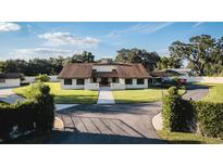 Charming home featuring lush landscaping, a circular driveway, and a welcoming front entrance at 2780 E Sam Allen Rd, Plant City, FL 33565