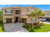 Beautiful two-story home boasts a stone facade, tile roof, lush landscaping and a three-car garage at 32324 Rosewood Meadow Ln, Wesley Chapel, FL 33543