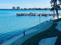 Scenic waterfront view featuring a boat dock, calm waters, and distant buildings under a clear blue sky at 5200 Brittany S Dr # 204, St Petersburg, FL 33715